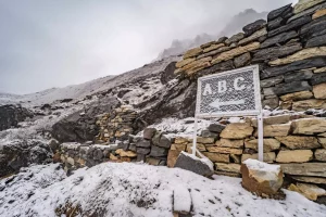 Cartello per il Campo Base dell'Annapurna (A.B.C.) al Campo Base del Machhapuchhre (M.B.C.) con la neve